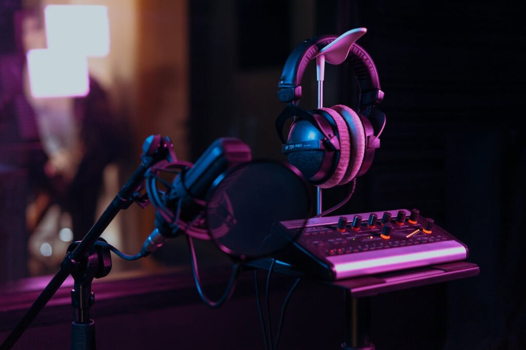 pexels-photo-7586656 High-quality audio recording studio setup with a microphone, headphones, and mixer board in dim lighting.
