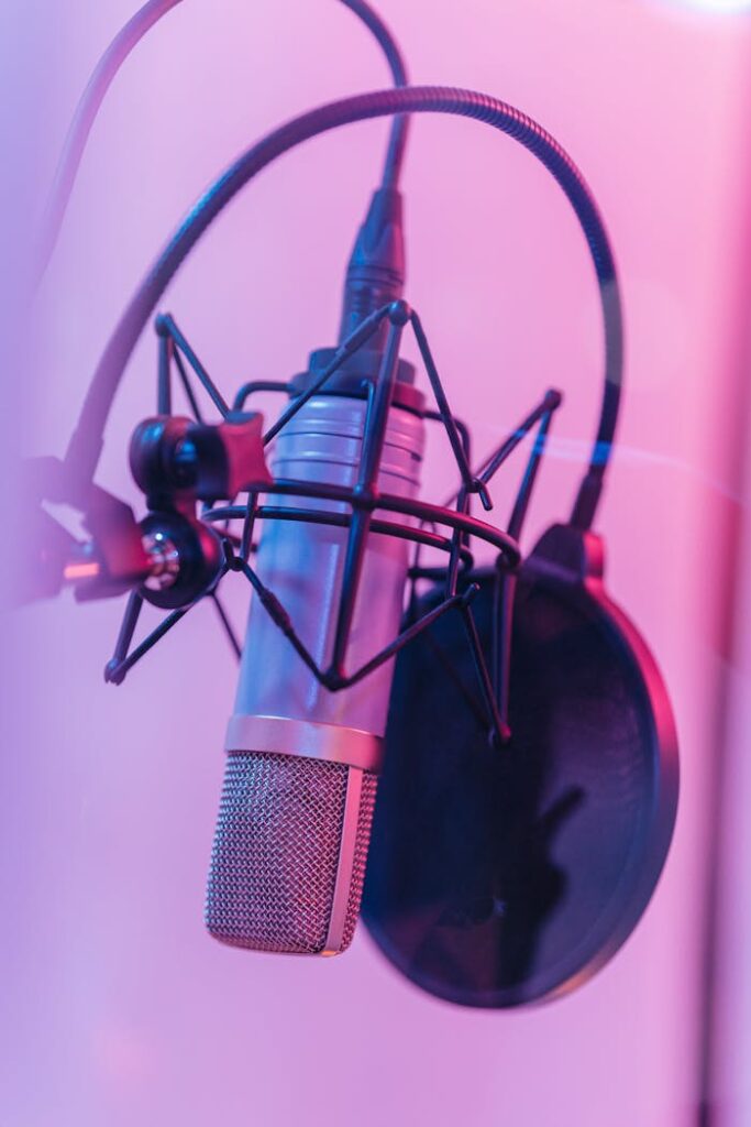 pexels-photo-8132528 Close-up of a studio microphone with pop filter in vibrant neon lighting. Perfect for music production concepts.